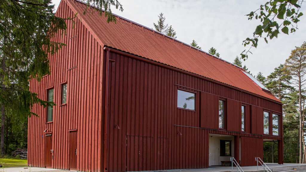 Räystäätön, kaksikerroksinen puurakennus, joka on kokonaisuudessaa käsitelty punatervalla